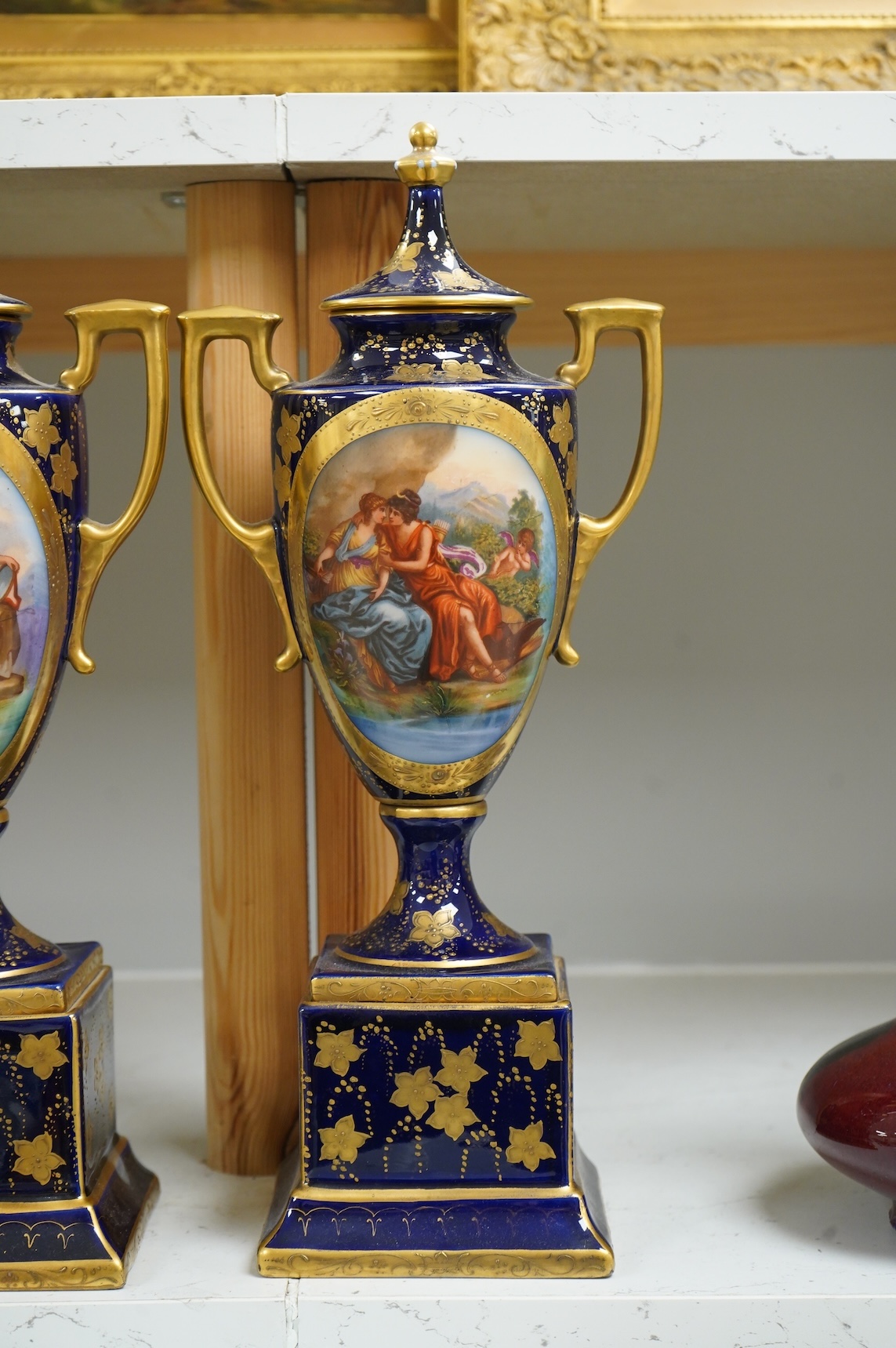 A pair of early 20th century Vienna style porcelain urns and covers, 36cm